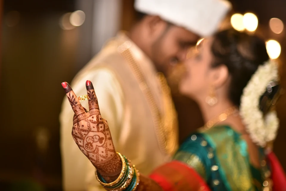 Wedding couple with the bride’s henna-covered hand in focus